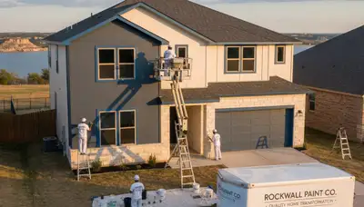 Professional house painters applying exterior paint on Dallas TX home